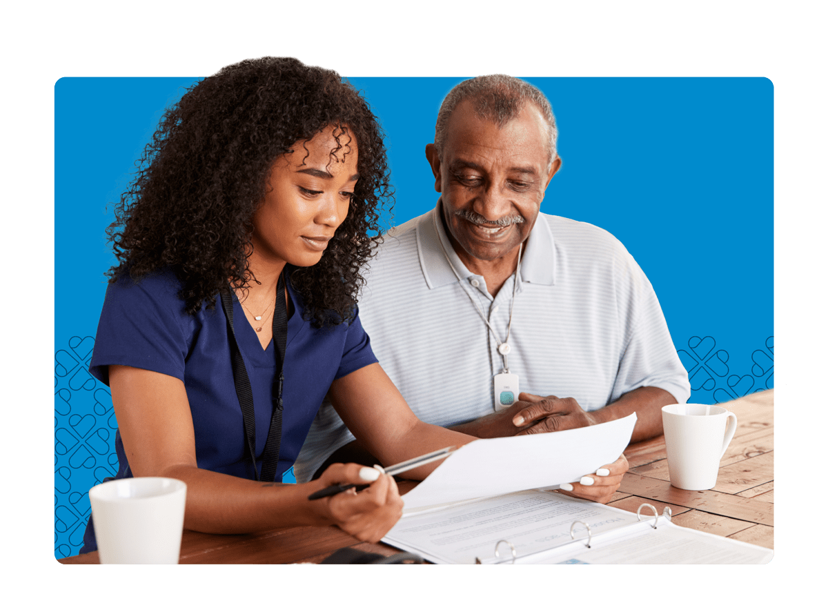 Caregiver helping elderly man with bills on a table