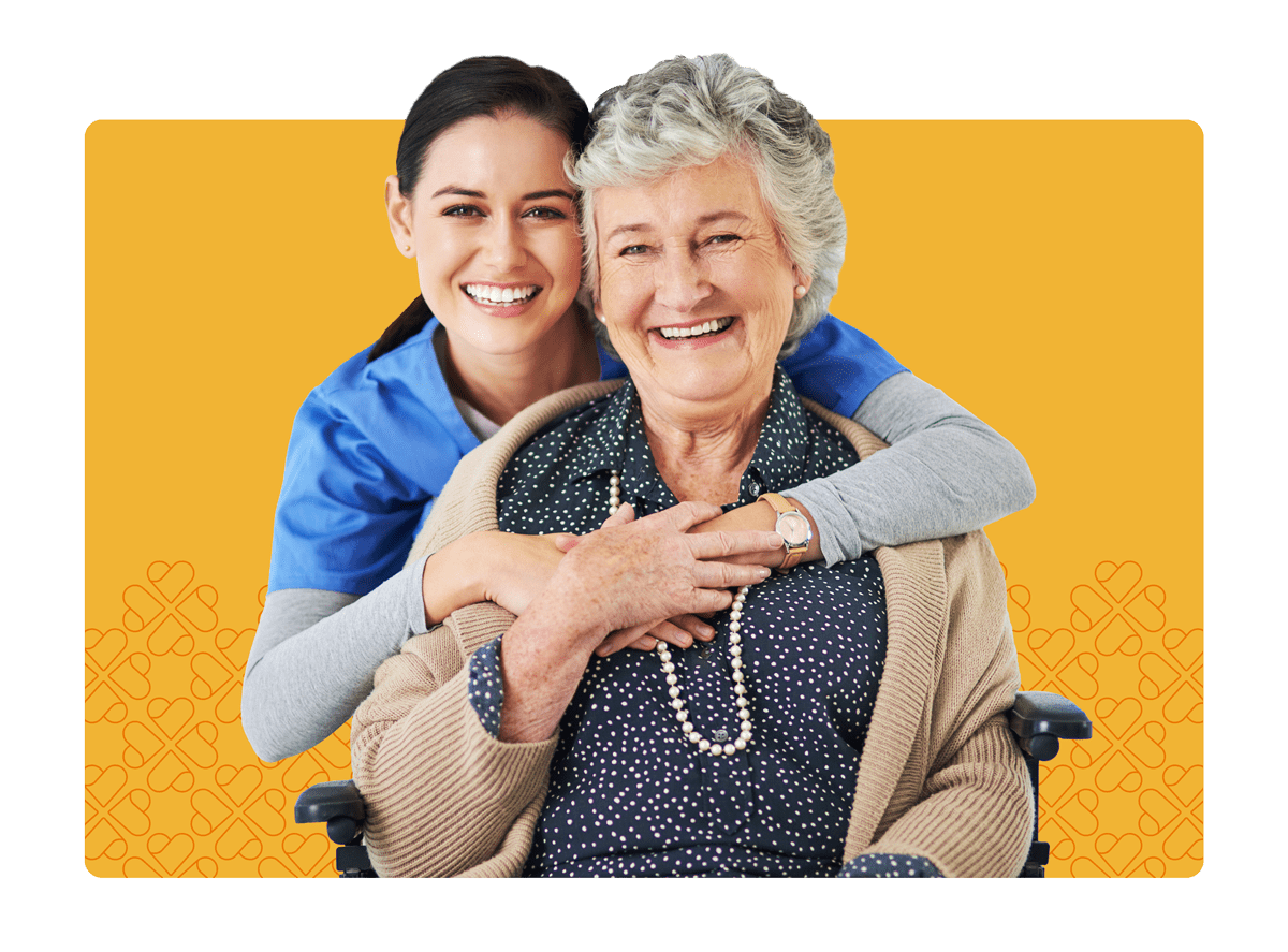 Caregiver hugging elderly woman in wheelchair
